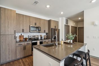 a kitchen with a large island with a counter top and a sink at Stella Luxury Apartment Homes, San Tan Valley, AZ